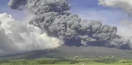 Paisaje del volcán Kanlaon en erupción, con lava y gases en un entorno natural que destaca su impacto en las comunidades
