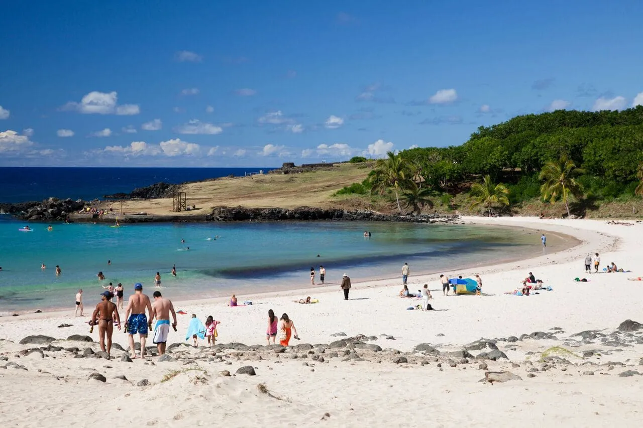 Vista panorámica de la bahía de Zapallar, con su playa, cerros verdes y senderos costeros enmarcados por el mar.