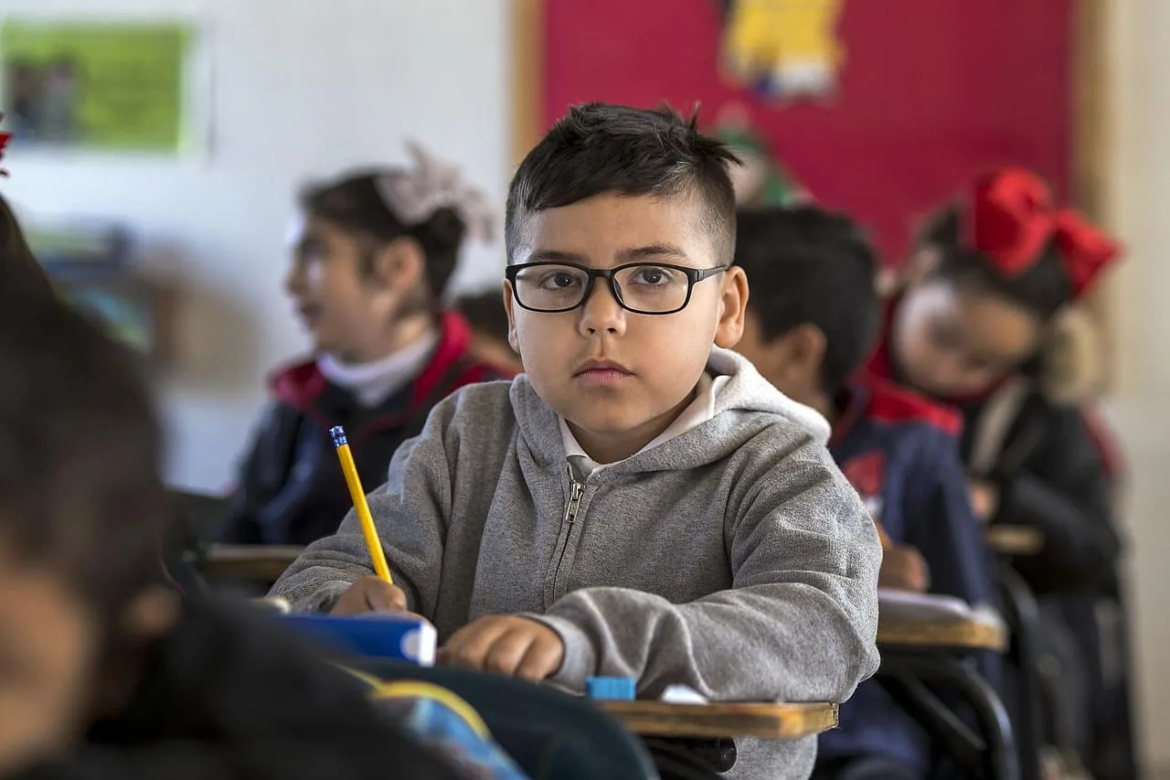 Persona estudiando con libros y computadora, apoyada por empeño para educación en Montepío Luz Saviñón